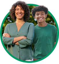 Adult and teen wearing green shirts smiling